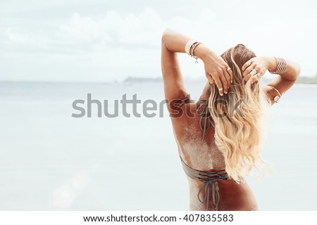 Beautiful bohemian styled and tanned girl at the beach in sunlight