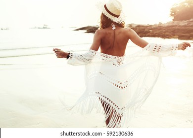 Beautiful Boho Styled Model Wearing White Crochet Swimsuit Posing On The Beach In Sunlight