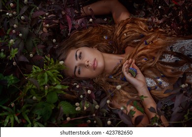 Beautiful Boho Woman Lying On The Grass With Flowers