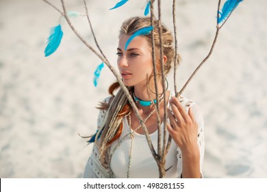 beautiful boho woman sitting on sand outdoors - Powered by Shutterstock