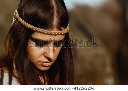 beautiful boho woman with warrior shaman make up on background of woods