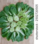 Beautiful bok choy vegetable arranged in a circle, like a flower on a wooden cutting board, The cut stalks from the center, while the green leaves fan outwards, creating a visually appealing design