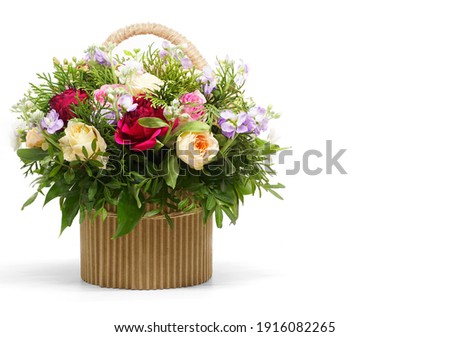 Beautiful bouquet of bright flowers in a flower basket, isolated on white background. Side location. Place for text. Happy Birthday, Valentine's Day, March 8 (International Women's Day), Mother's Day.