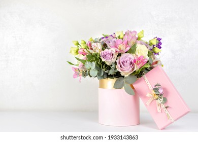 Beautiful bouquet of flowers in round box and pink gift box on a white table. Gift for holiday, birthday, Wedding, Mother's Day, Valentine's day, Women's Day. Floral arrangement in a hat box. - Shutterstock ID 1933143863
