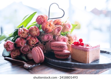 Beautiful bouquet of flowers with sweet delicacies. Heart shape, sweet pastries with pink roses and tulips on wooden table. Background for mother's day and wedding. - Powered by Shutterstock