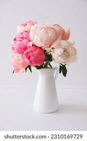 Beautiful bouquet of fresh coral peony flowers in full bloom in vase. Floral still life with blooming peonies. 