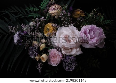 Beautiful bouquet of peonies and different flowers on a black background. Floral background. Pattern from natural flowers. Floral card design with dark vintage effect