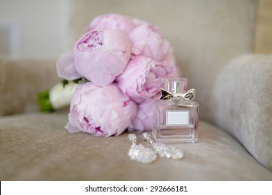 Beautiful bouquet and perfume bottle for bride and groom. Beauty of wedding accessories indoors. Close-up bridal bunch of florets and perfumery. Female and male decoration. Colorful flowers for woman - Powered by Shutterstock