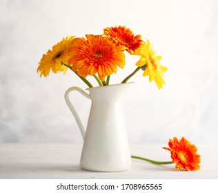 Beautiful Bouquet Of Red And Yellow Flowers In White Vase On Wooden Table, Front View. Autumn Still Life With Flowers.