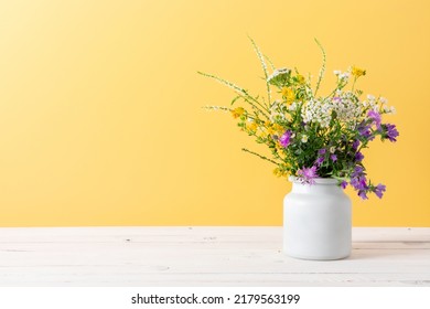 Beautiful bouquet of wild summer flowers in vase against yellow wall.  - Shutterstock ID 2179563199