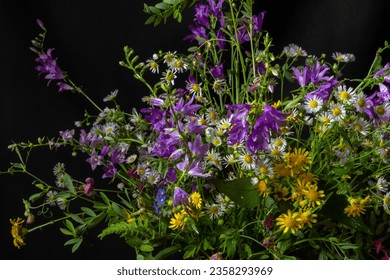 Beautiful bouquet of wildflowers on a black background. Blur and selective focus. - Shutterstock ID 2358293969