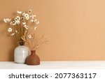 Beautiful bouquets of dry plants against a brown wall