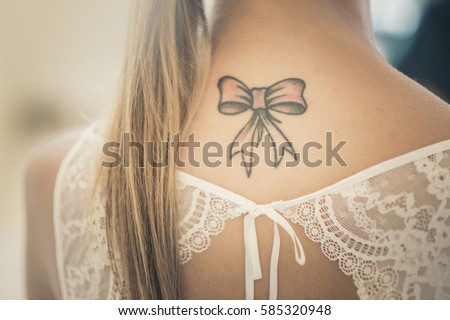 beautiful bow tatoo on bridal neck. (vintage effect)