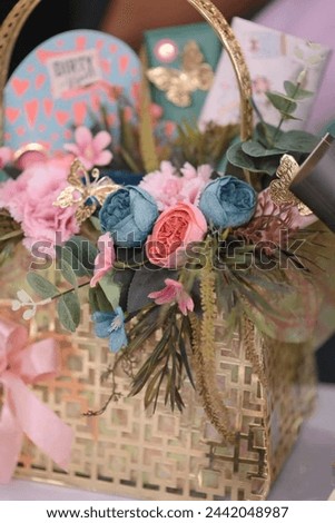 A Beautiful Box filled with colorful flowers and assorted items on a wooden table.
Colorful flowers and miscellaneous items in a Box on a table.
