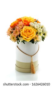 beautiful box of flowers on a white glass table, close-up with a blurred background. floral arrangement in yellow tones as a natural background for the designer. roses, chrysanthemums, greenery