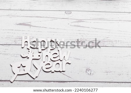 beautiful branches of a Christmas tree with cones and toys on a white wooden background with the inscription Happy New Year close-up