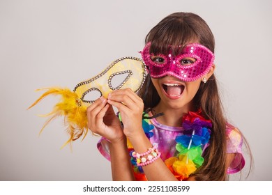 Beautiful Brazilian girl, child, dressed for carnival in Brazil. with carnival mask, close-up photo.