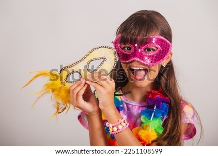 Beautiful Brazilian girl, child, dressed for carnival in Brazil. with carnival mask, close-up photo.