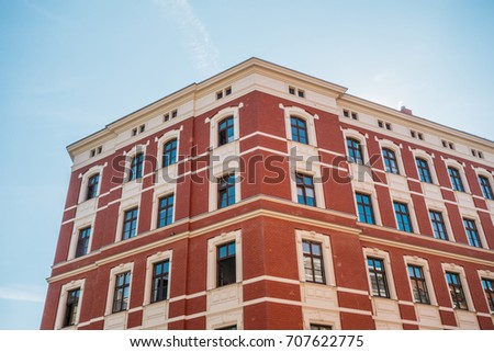 beautiful brick corner building with red facade and clean sky