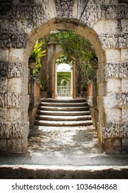 Beautiful Brick Stone Archway With Receding Path, Stairs And Overhanging Trees Leading To Garden Entrance. Inspired By Italian Renaissance And Mediterranean Revival Architecture With Baroque Elements.