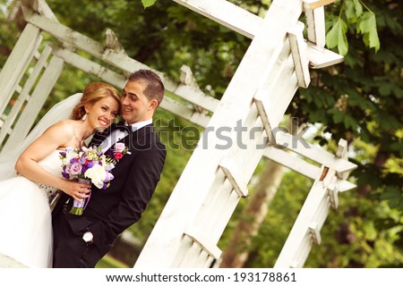 Beautiful bridal couple having fun in the park on their wedding day
