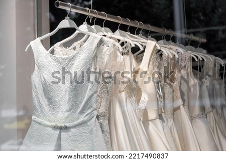 Beautiful bridal dress on hangers. Wedding dress close up at the wedding salon. Wedding dresses hanging on a hanger. Interior of bridal salon.