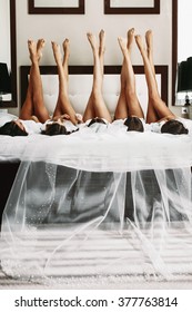 Beautiful bride & bridesmaids showing off sexy legs on bed
