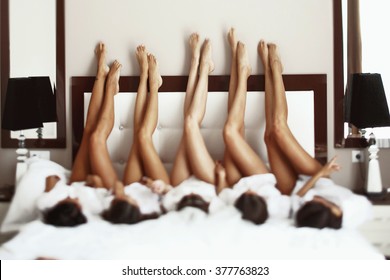 Beautiful bride & bridesmaids showing off sexy legs on bed