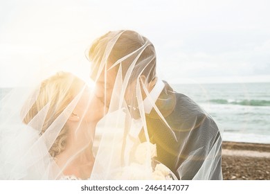 Beautiful Bride and Groom During an Outdoors Wedding Ceremony on an Ocean Beach at Sunset. Perfect Venue for Romantic Couple to Get Married, Exchange Rings, Kiss and Share