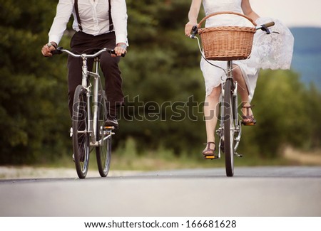 Beautiful bride and groom riding on the bikes