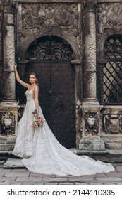 Beautiful Bride In A Long White Wedding Dress On A Background Of Black Old Building