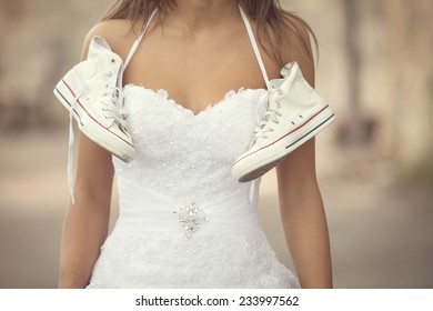 Beautiful bride outdoors , wedding sneakers (cross processing)