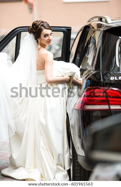 Beautiful bride\
sits down in black Mercedes\
GLE