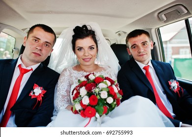 Beautiful Bride Sitting In The Wedding Car With Groomsmen.