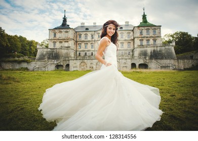 beautiful bride stands next to the castle