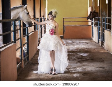 Beautiful bride touching a horse at the ranch
