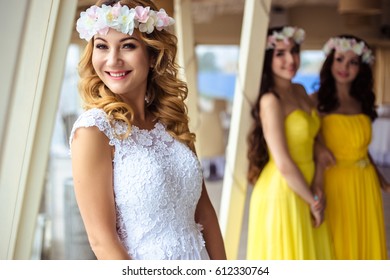 Beautiful Bride And Two Bridesmaids In Yellow Similar Dresses Together In A Sea Restaurant