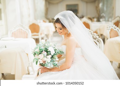 Beautiful Bride With Wedding Bouquet Posing In Hotel