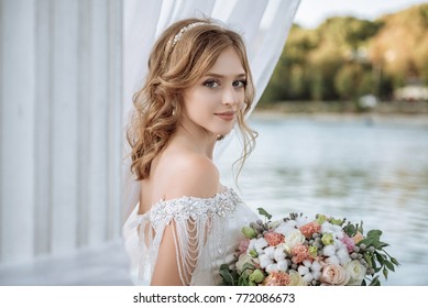 Красивая невеста с свадебными цветами букет, привлекательная женщина в свадебном платье. Счастливая молодая женщина. Невеста со свадебным макияжем и прической. Улыбающая невеста. День свадьбы. Великолепная невеста. Брак.