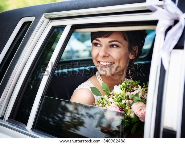 Beautiful bride\
in wedding limousine at summer\
day