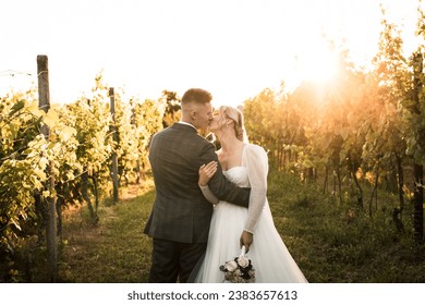 beautiful bride in white dress and groom kissing in the middle of vineyard and grapes, groom holding bride,sunny day, love is in the air, wedding photography,models - Powered by Shutterstock