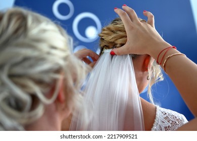 Beautiful bride white veil is put by a witness. Back, hands, close-up - Shutterstock ID 2217909521
