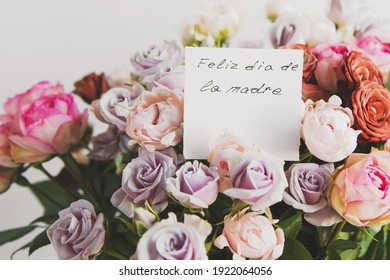 beautiful bright bouquet of colorful roses with white card with the inscription happy mother s day on spanish, concept of congratulations on the holiday 