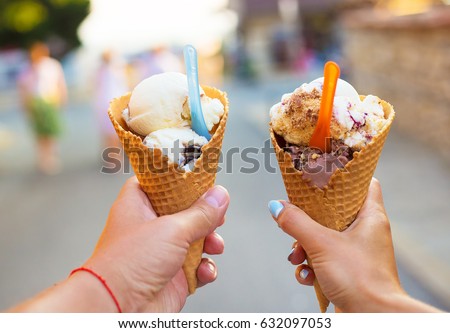 Beautiful bright ice cream with different flavors in the hands of a couple