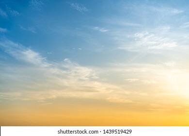 Beautiful bright orange - yellow cloudy sky during the sunrise and sunset. Beautiful scenic gradient sky between hot and cool tone of twilight sky with a cloud. Sun beam background.