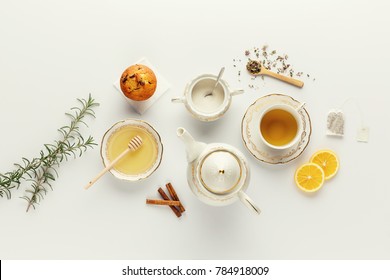 Beautiful bright tea set up. White ceramic tea pots and tea ingredients, on top of the white table. - Powered by Shutterstock