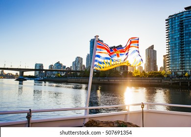 The beautiful British Columbia flag in front of downtown Vancouver at sunset. 
