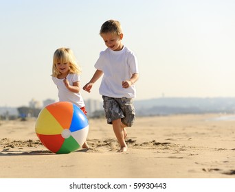 Beautiful brother and sister play with a beach ball outdoors - Powered by Shutterstock