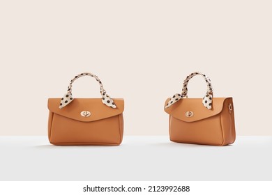Beautiful brown leather female fashion handbags isolated on light beige background, front view - Shutterstock ID 2123992688