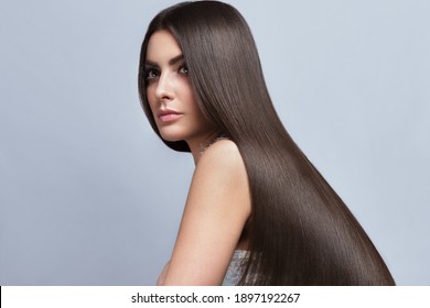 Beautiful Brown-haired Girl With A Perfectly Smooth Hair, And Classic Make-up. Beauty Face And Hair. Picture Taken In The Studio.